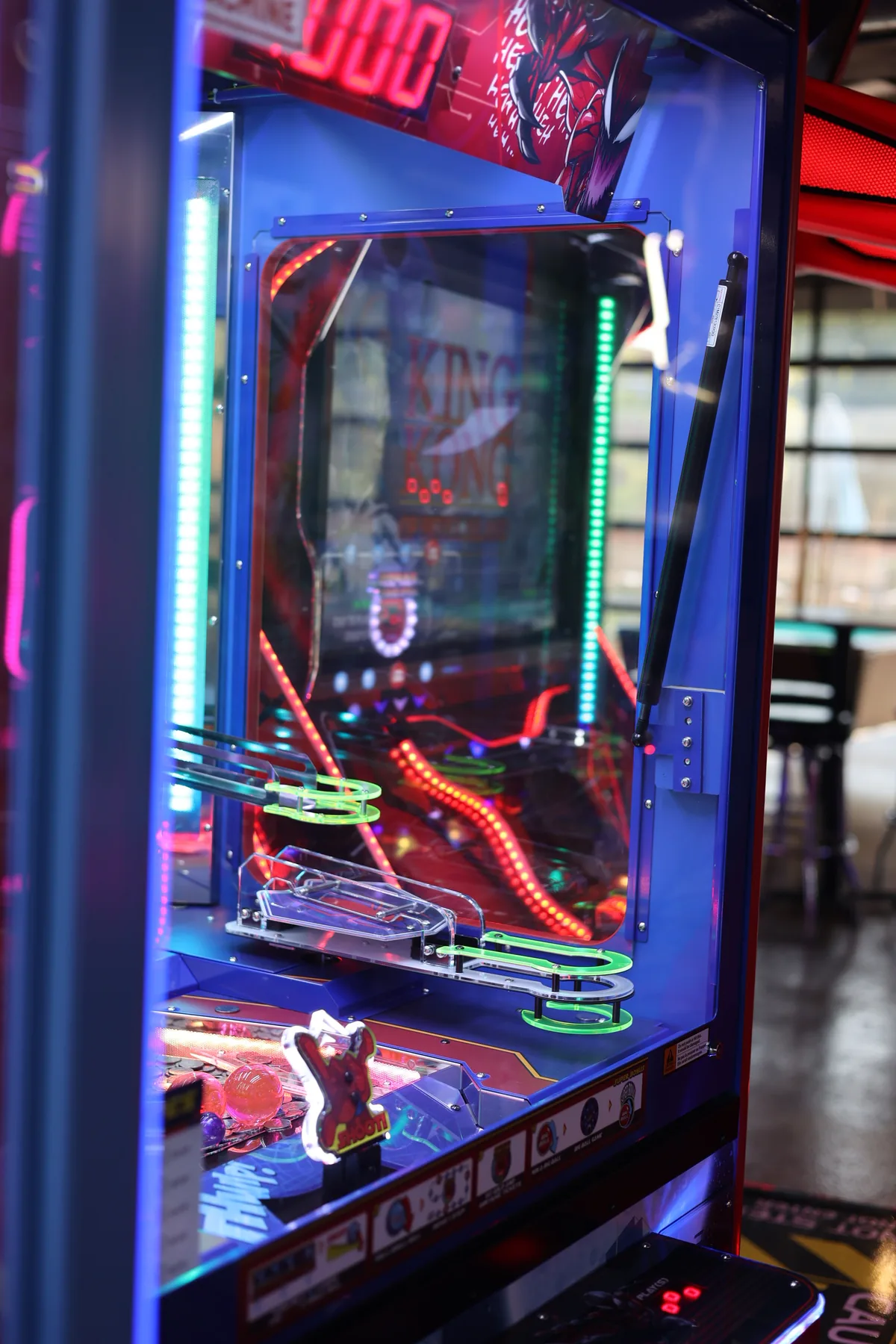 A lit pinball and skill machine on the arcade floor