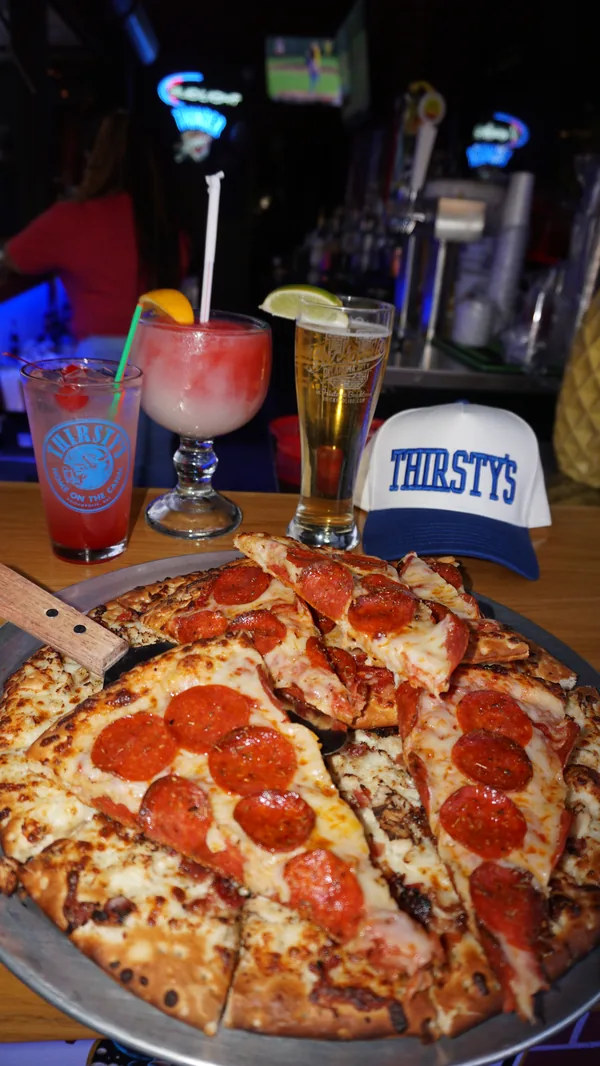 A pepperoni pizza and drinks on a table at Brickopolis