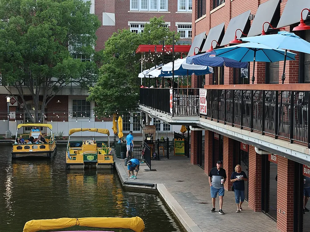 A water taxi passing the Brickopolis patio on the Bricktown Canal