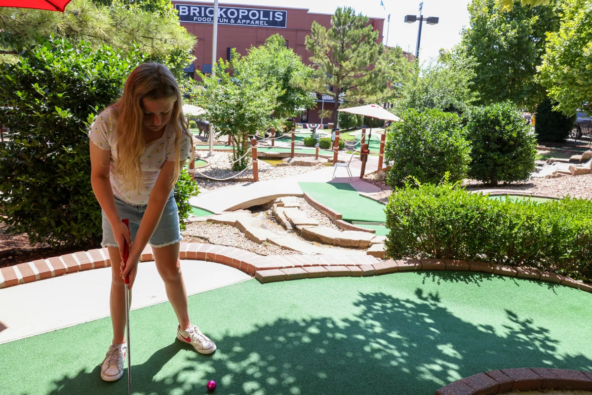 A player on the canal-side mini golf course